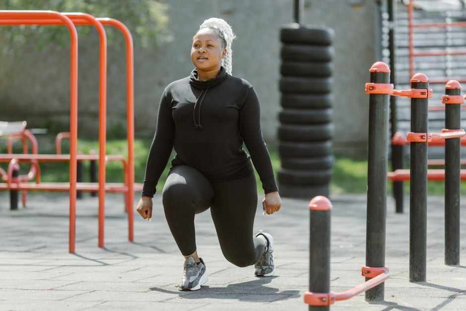 Fit woman performing lunges at an outdoor gym, embracing a healthy lifestyle.