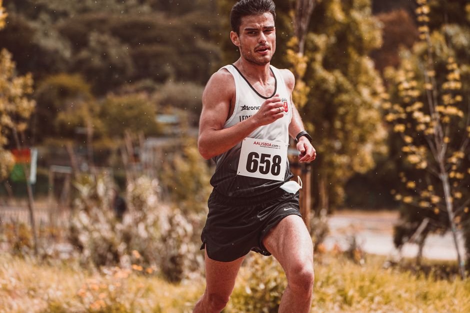 Athlete participating in an outdoor marathon with race number 658 during daytime.