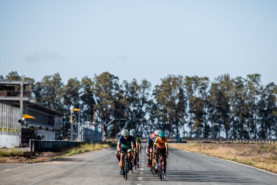Cyclists enjoying a group ride on a country road amidst scenic surroundings.