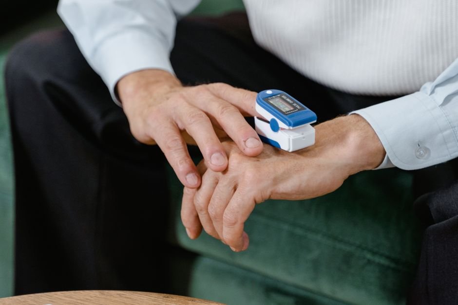A pulse oximeter is monitoring blood oxygen levels on an adult's finger.