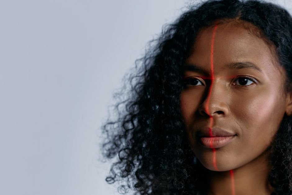 Close-up of a woman scanned with a laser for facial recognition, showcasing advanced technology.