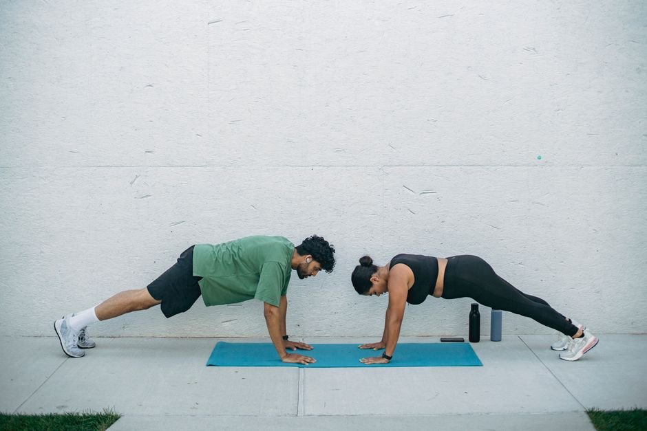 Two adults in plank positions on yoga mats enhancing core strength and fitness.