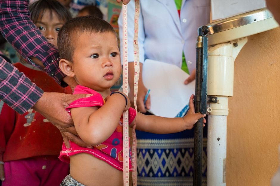 A child receives a health checkup in a rural Laos healthcare facility.
