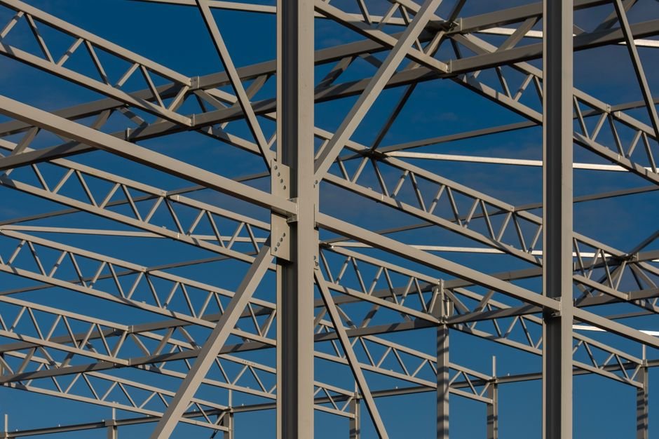 Detailed view of a steel framework structure against a blue sky, showcasing modern construction elements.