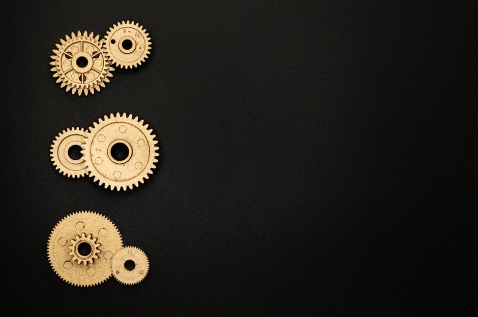 Detailed view of intricate golden gears on a sleek black background, showcasing mechanical engineering.