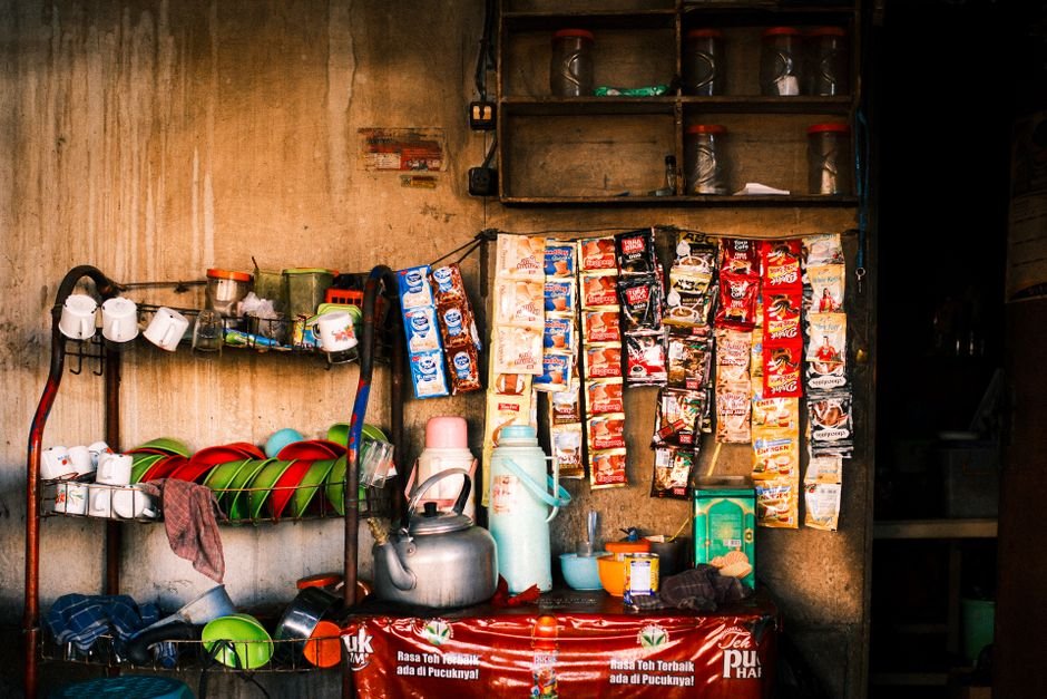 A colorful display of a traditional Indonesian street vendor's stall with assorted goods and kitchenware.