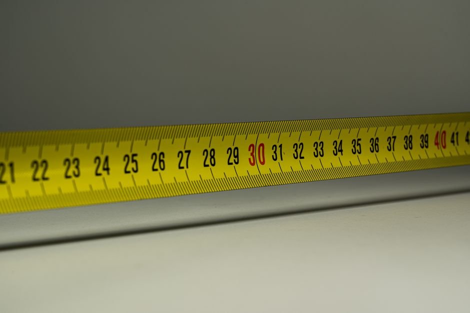 Close-up view of a yellow measuring tape with centimeter marks, emphasizing precision in measurement.