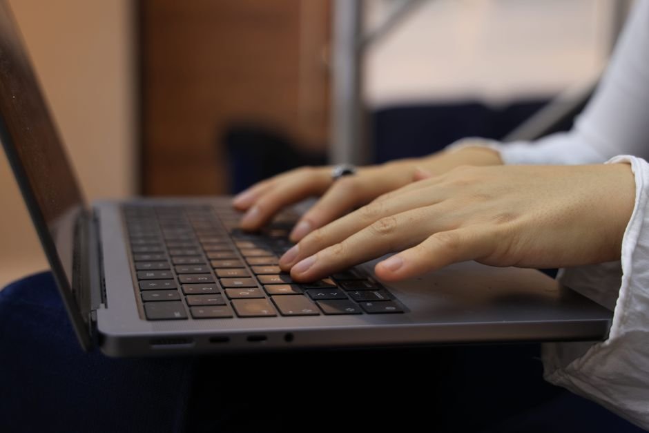 Hands typing on a laptop keyboard in an indoor setting. Perfect for business and technology themes.