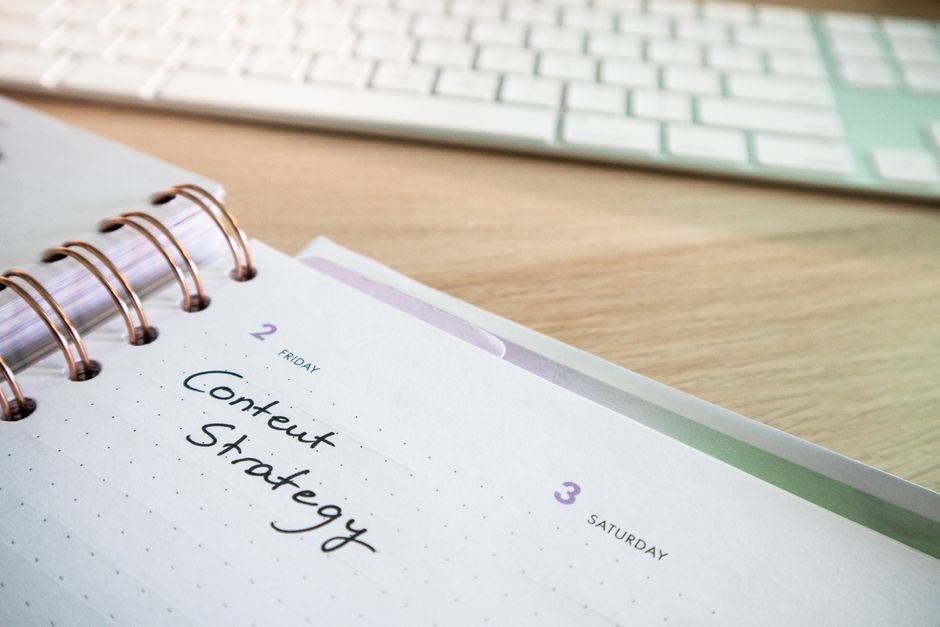 Content strategy written in planner with keyboard on wooden desk