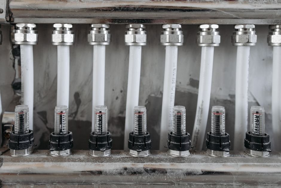 Detailed view of a network of pipes with valves in a metal framework, emphasizing industrial mechanics.
