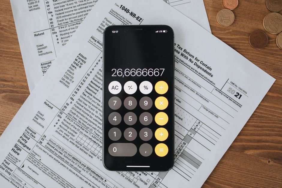 Mobile calculator app on tax documents, highlighting financial calculations and tax preparation.